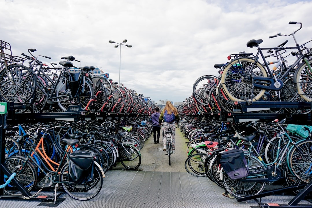 Couple walking between rows of parked bicycles in a parking garage.